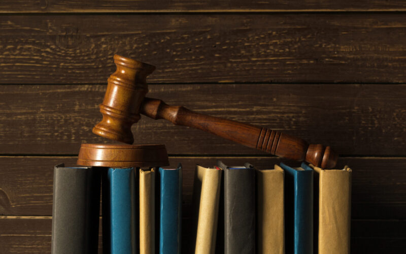 Gavel With Books On Old Wooden Desk